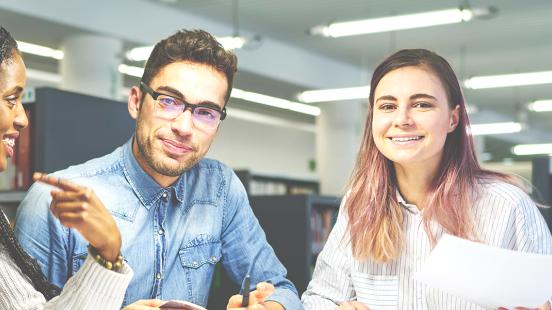 Étudiantes et étudiants souriants faisant un travail d'équipe