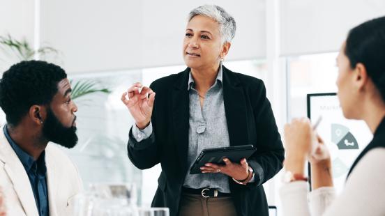femme d'affaires avec une tablette devant groupe de recherche