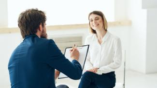 Femme qui discute avec un homme qui prend des notes