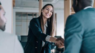 Femme souriante donnant poignée de main à une personne de dos