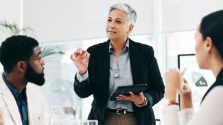 femme d'affaires avec une tablette devant groupe de recherche