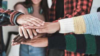 Groupe de jeunes empilant leurs mains ensemble en guise de soutien