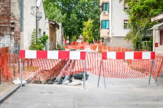 Travaux de canalisation dans le quartier de la ville, barrières routières et filets de sécurité autour du chantier