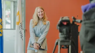 Femme souriant devant une caméra
