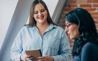 Femme souriante montrant un livre