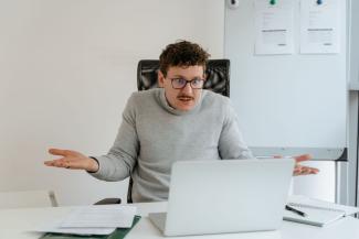 Homme s'impatientant devant un ordinateur portable