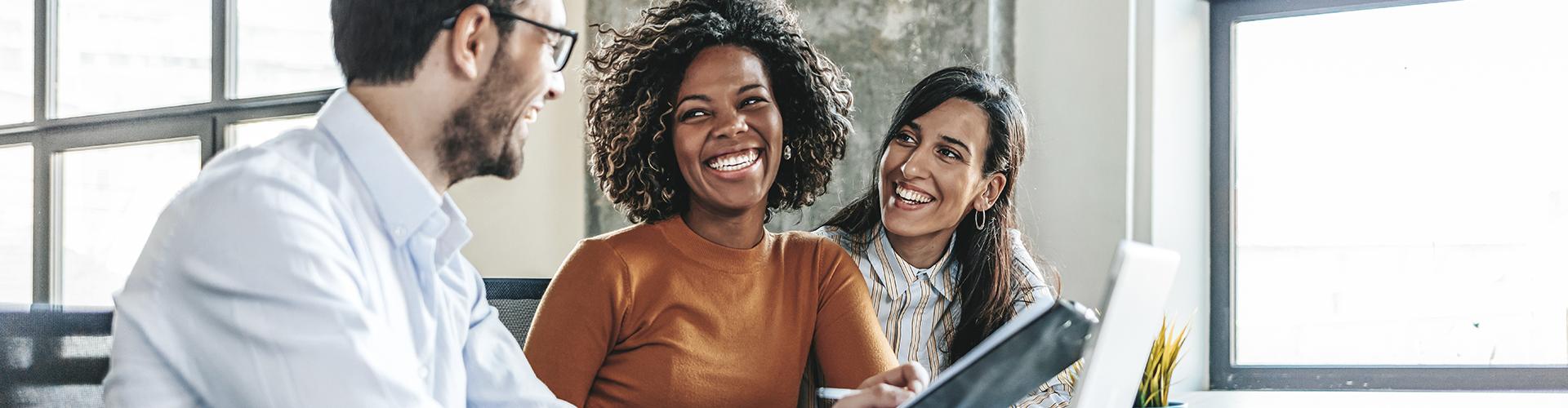 Deux femmes souriants et un homme avec regards complices