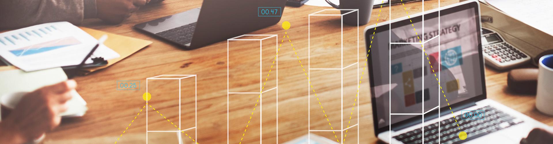 Vue sur table de travail avec portable et dessins de graphique illustrant la progression, le succès